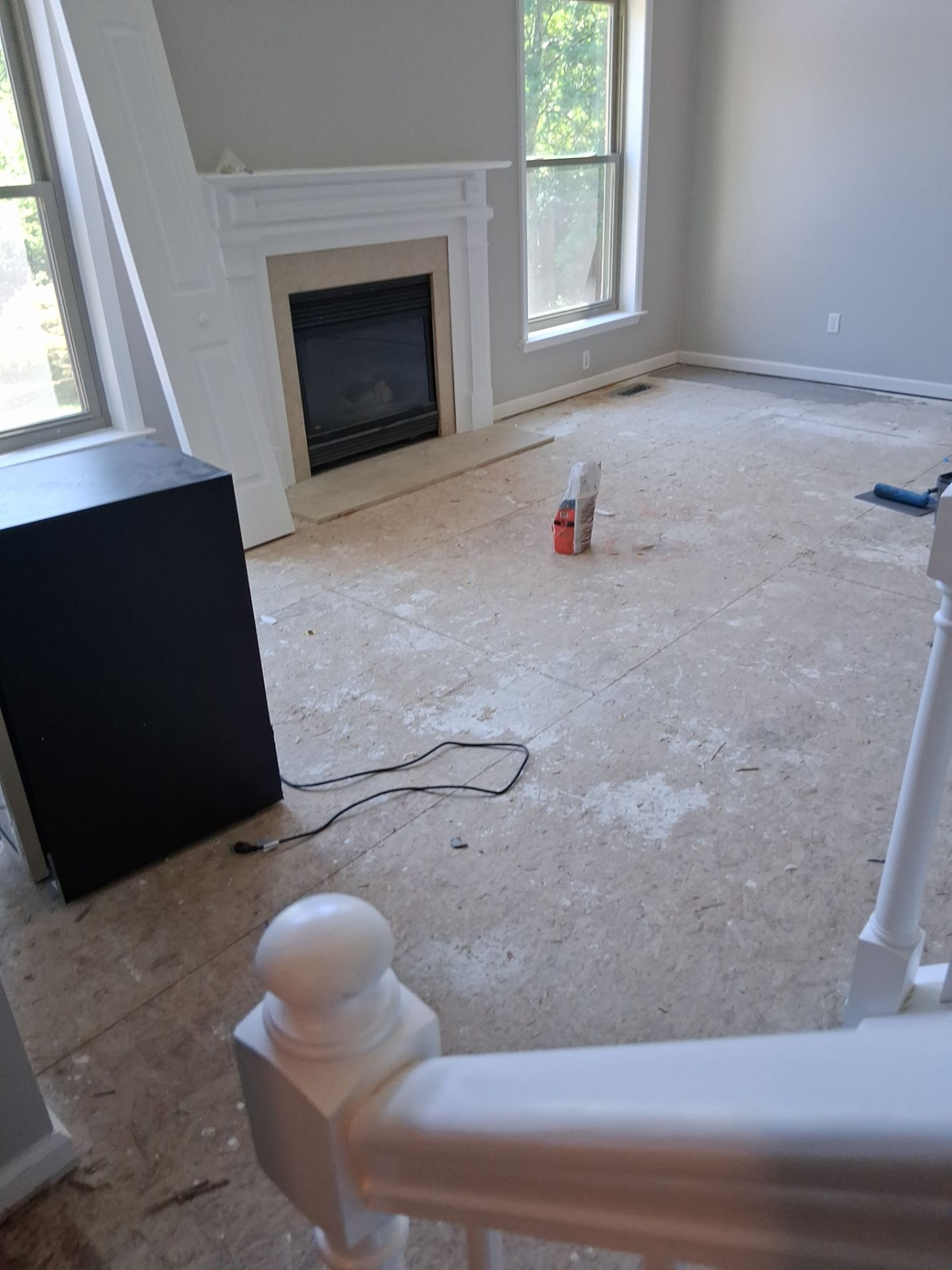 Great room before reconstruction - exposed subfloor, debris, and damaged finishes